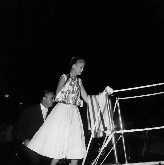 Grace Kelly wearing an Hermès scarf as a sling aboard Aristotle Onassis’s yacht in 1959.