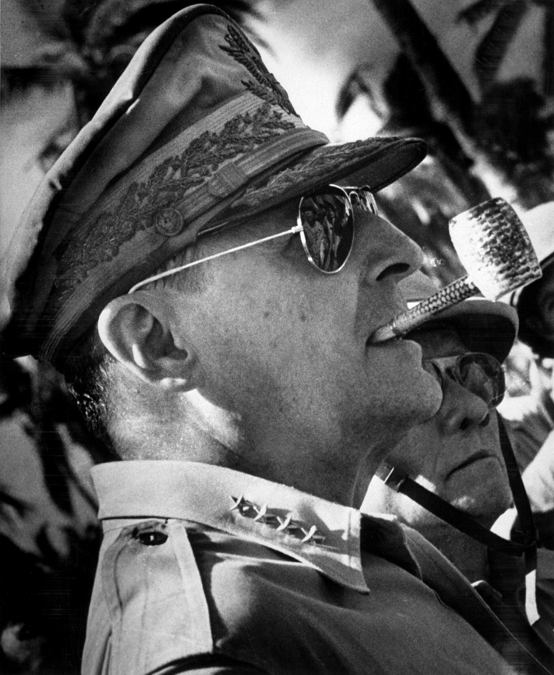 US General MacArthur's signature look included his ornate hat, corncob pipe, and Aviator sunglasses.